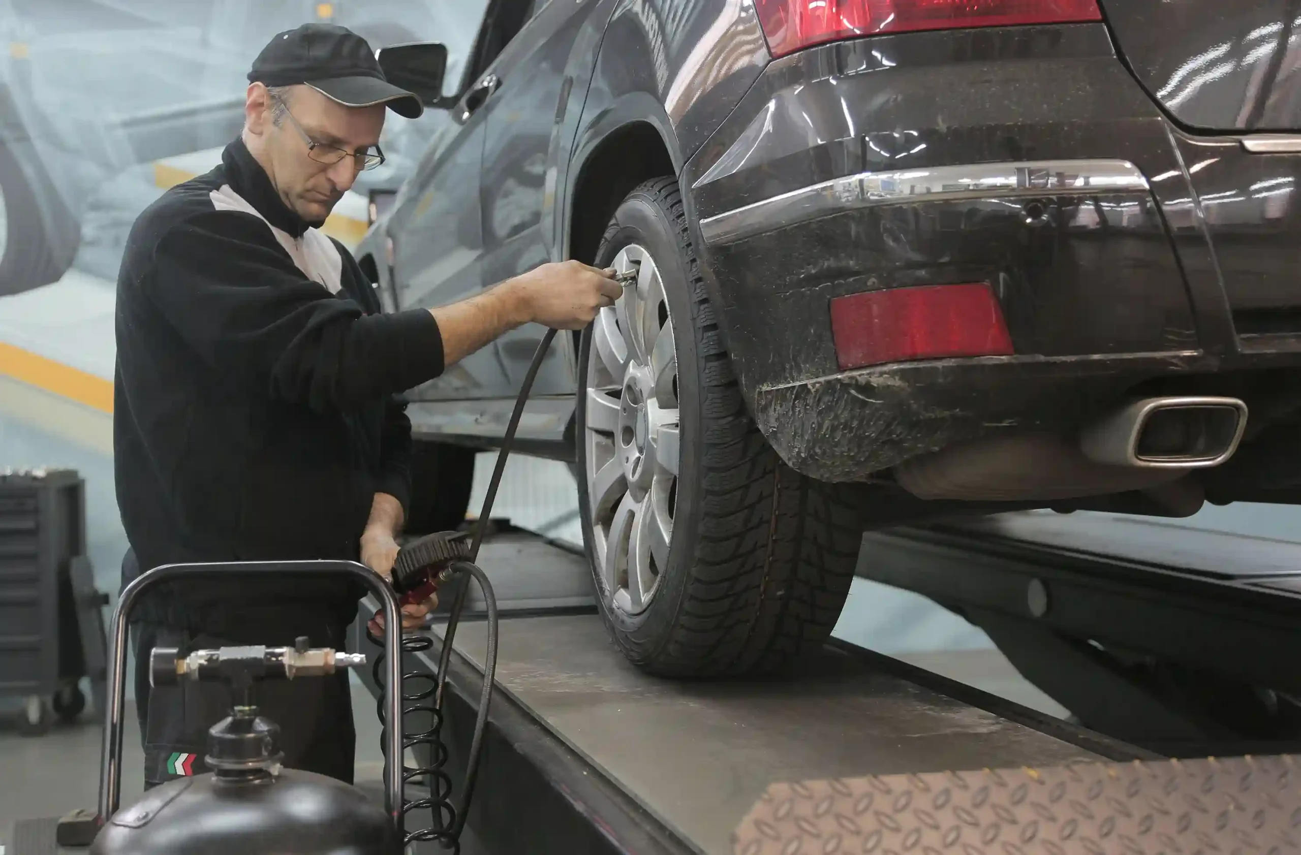 Mechanic performing wheel alignment during suspension inspection