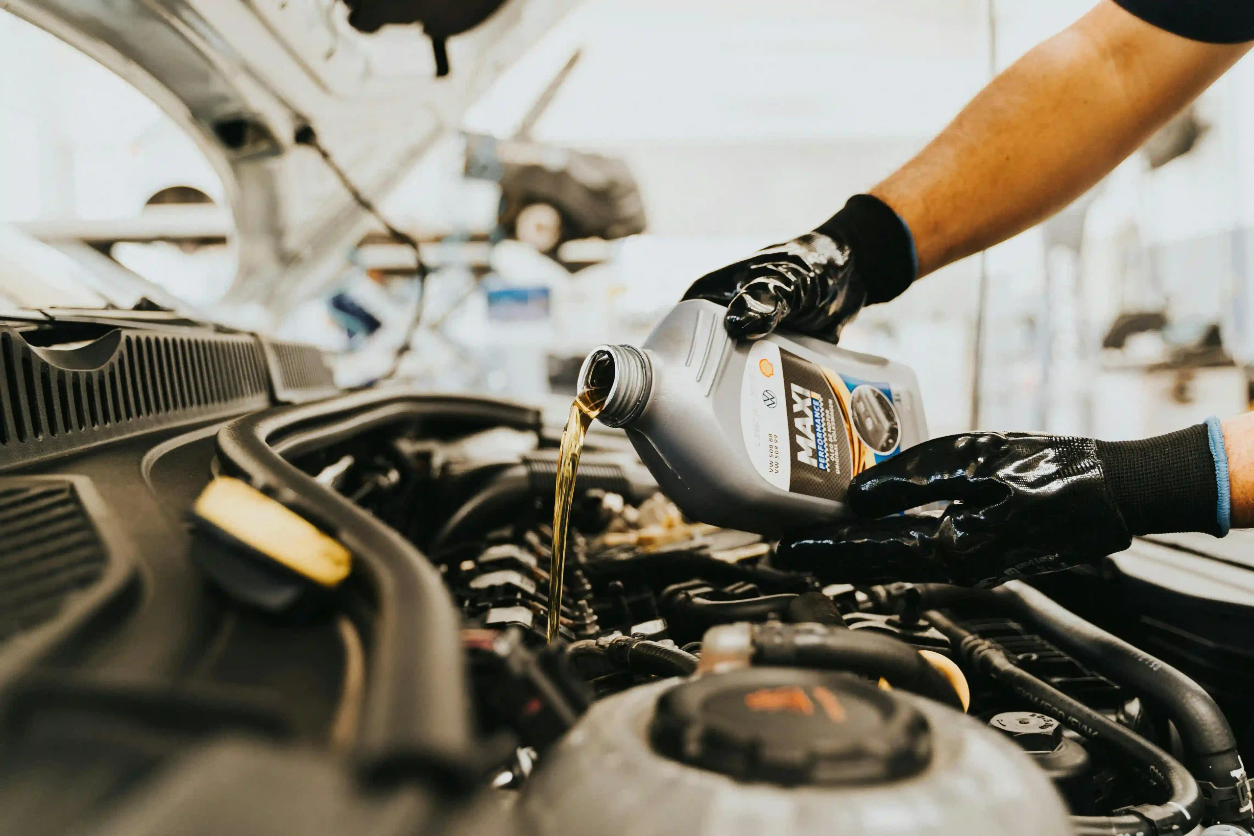 Mechanic pouring engine oil into a car engine