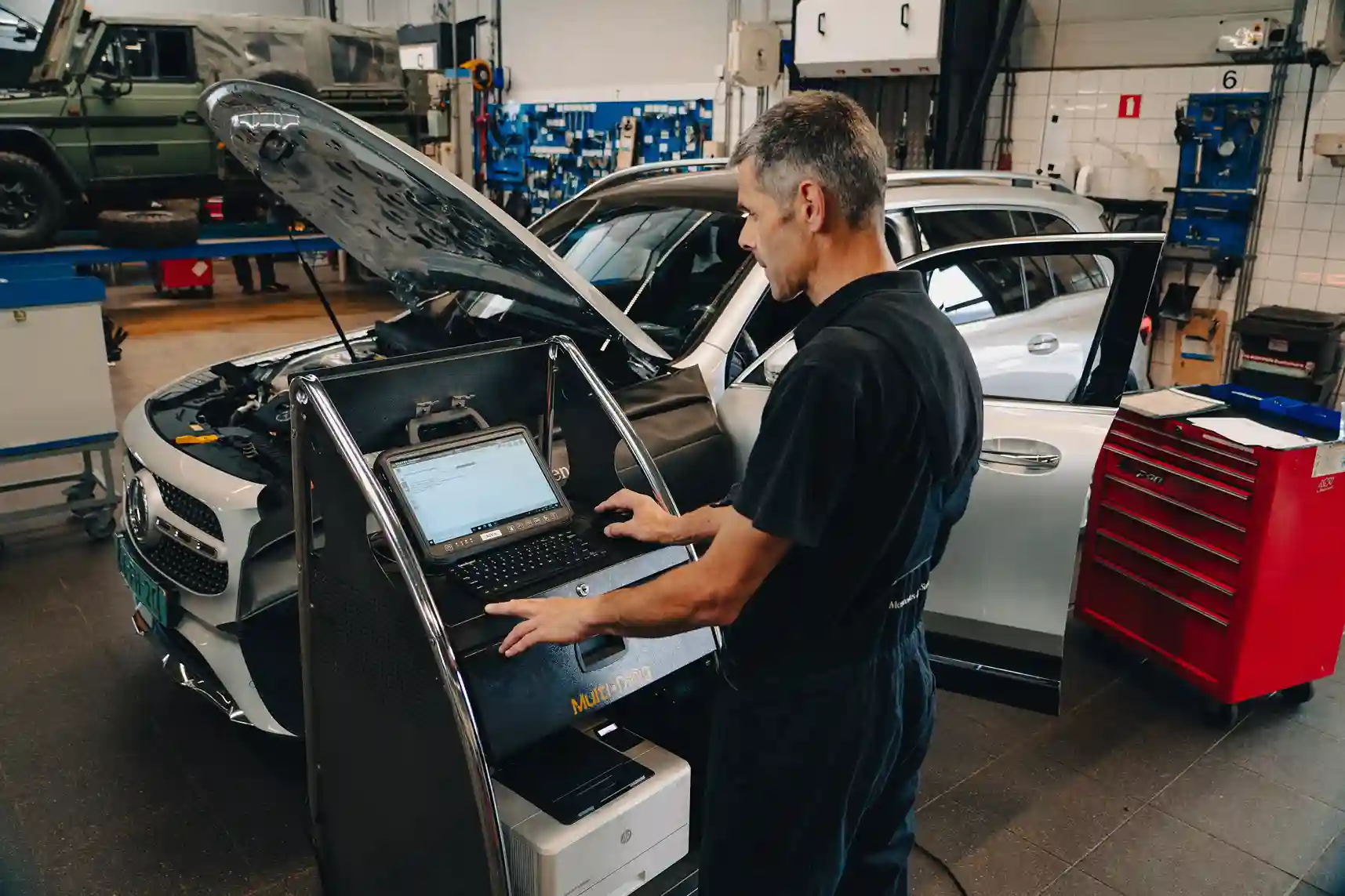 Mechanic using diagnostic equipment on a Mercedes-Benz