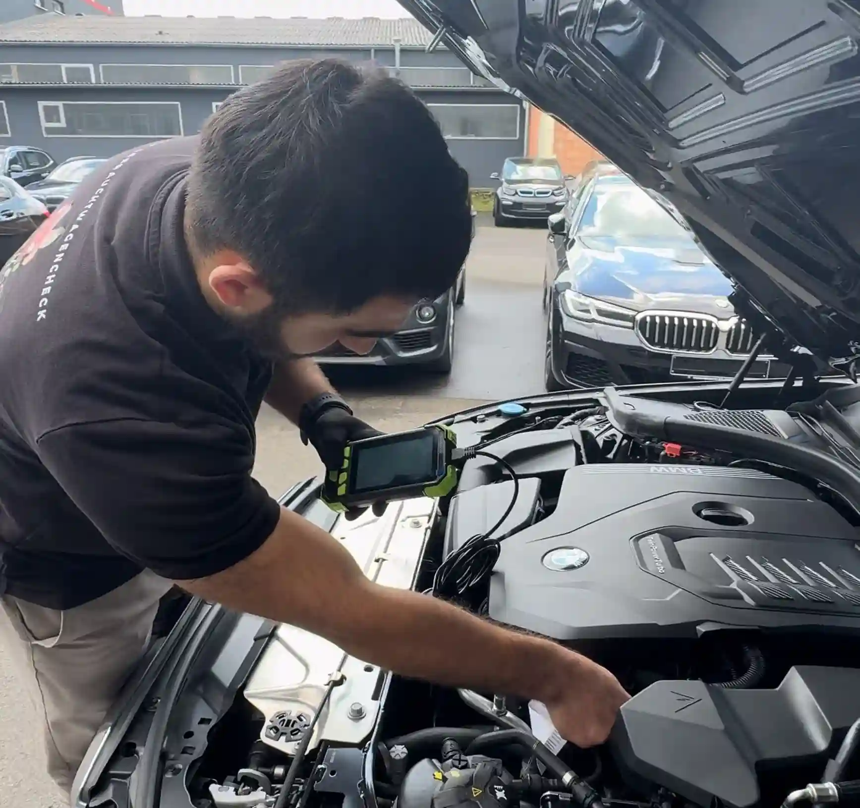 Mechanic performing a diagnostic check on a BMW engine