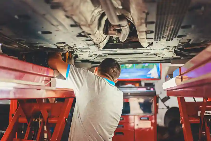 Professional mechanic inspecting a Mercedes vehicle transmission