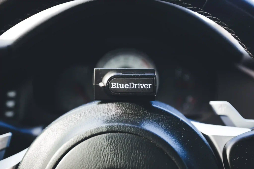 Bluetooth OBD code reader on a car steering wheel