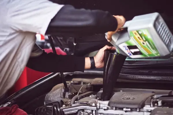 Old engine oil being drained during a car oil change