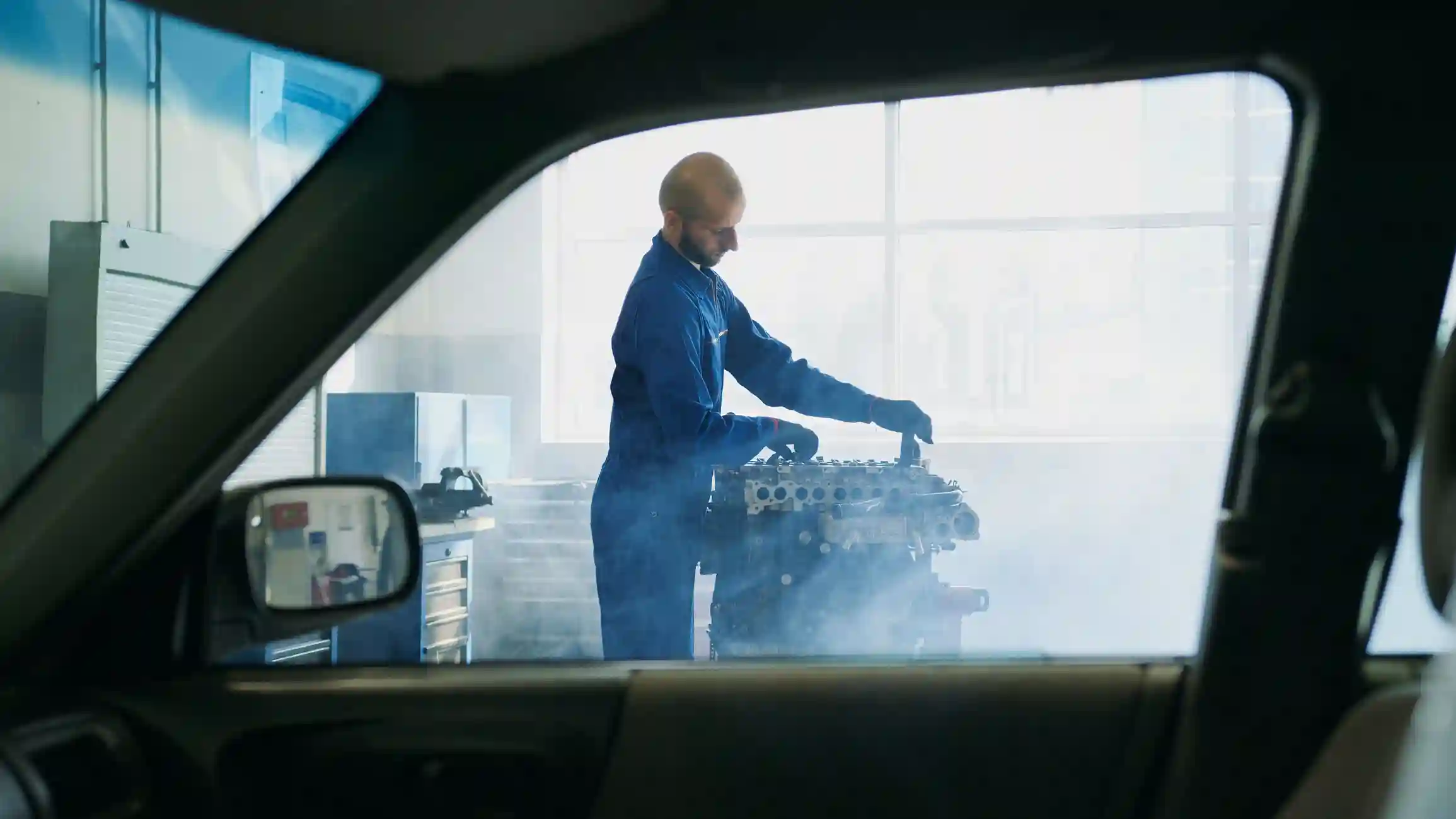 Mechanic working on a car engine in a garage