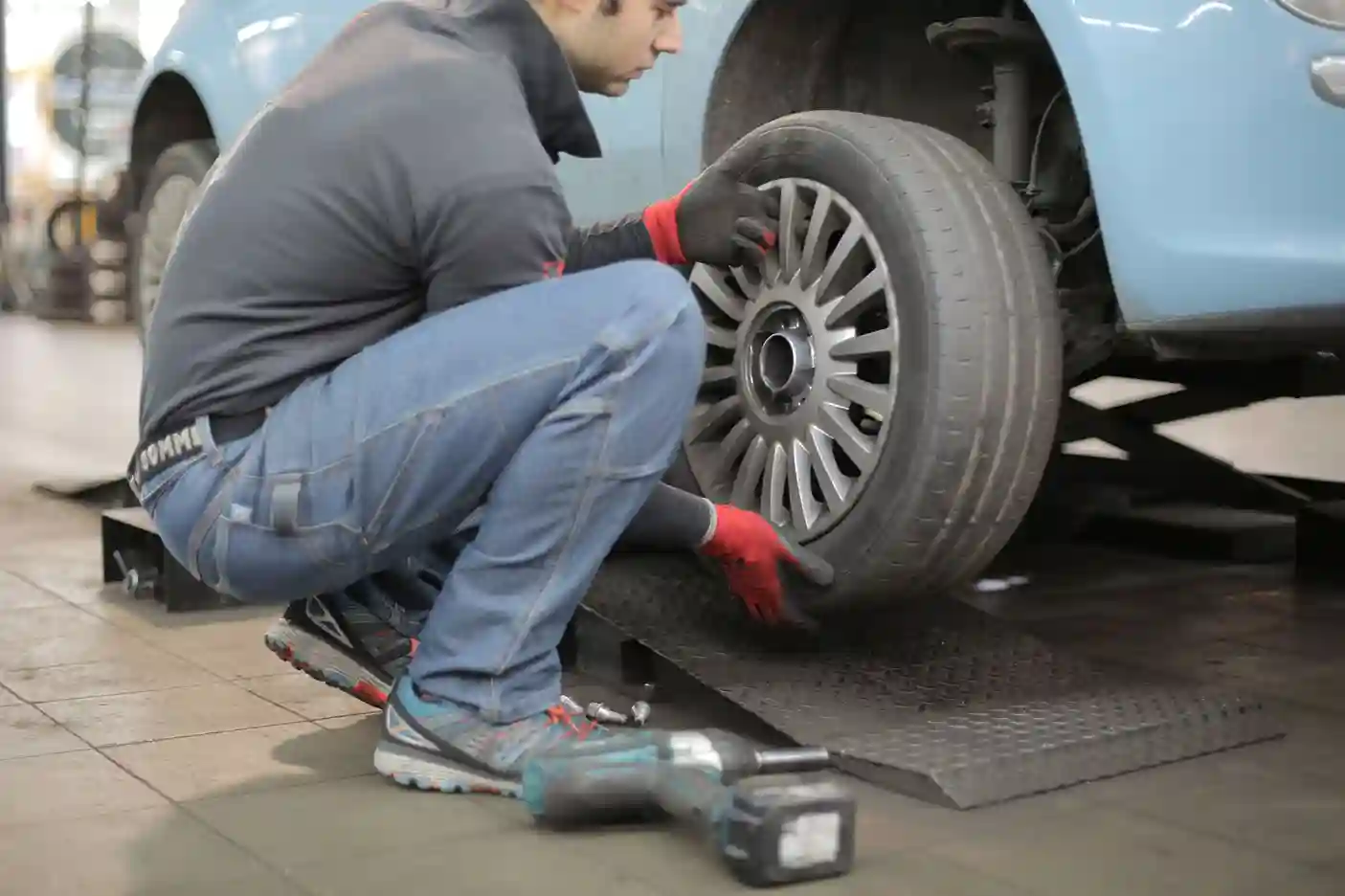 Mechanic inspecting and rotating a car tire