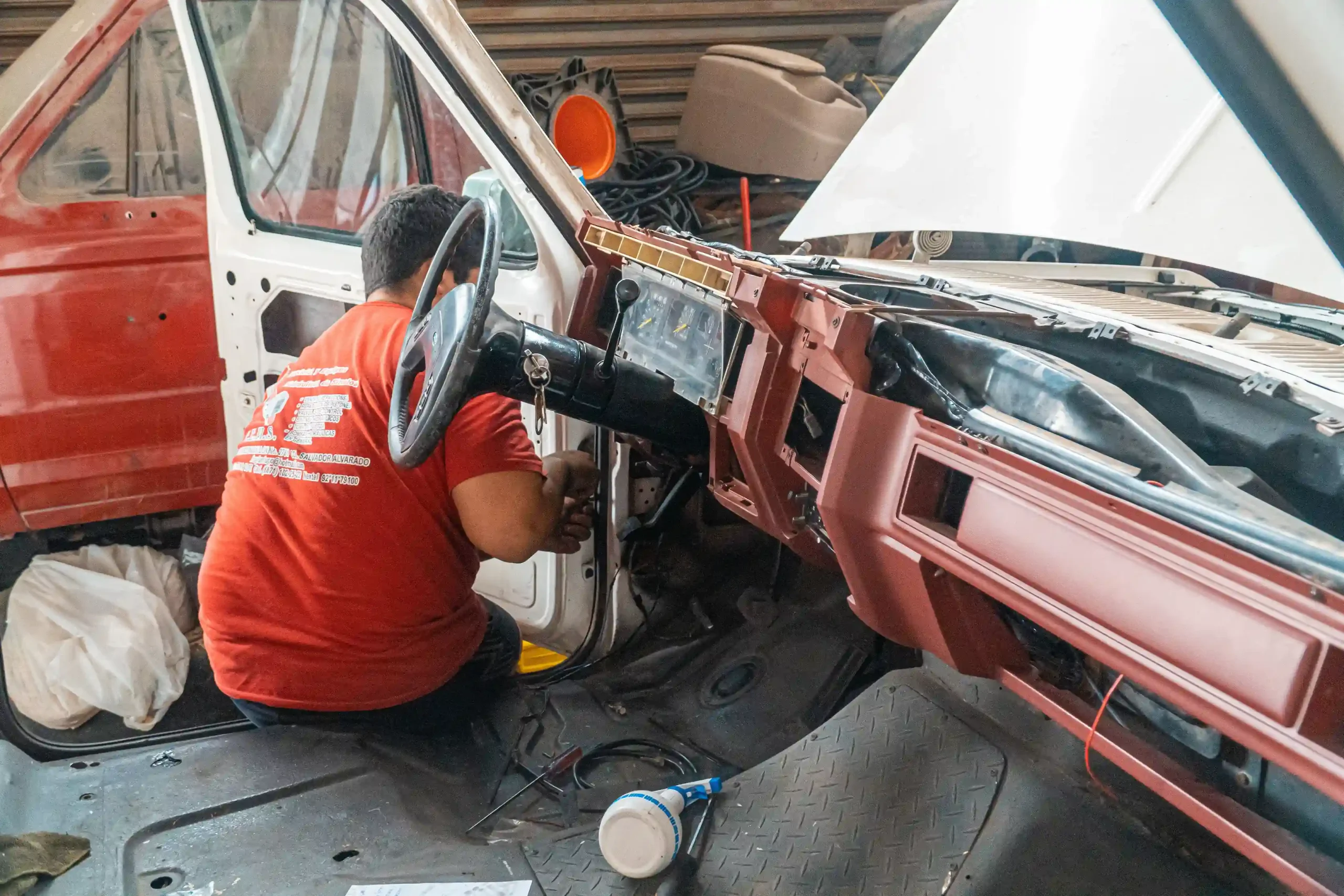 Mechanic inspecting a car dashboard during vehicle repair