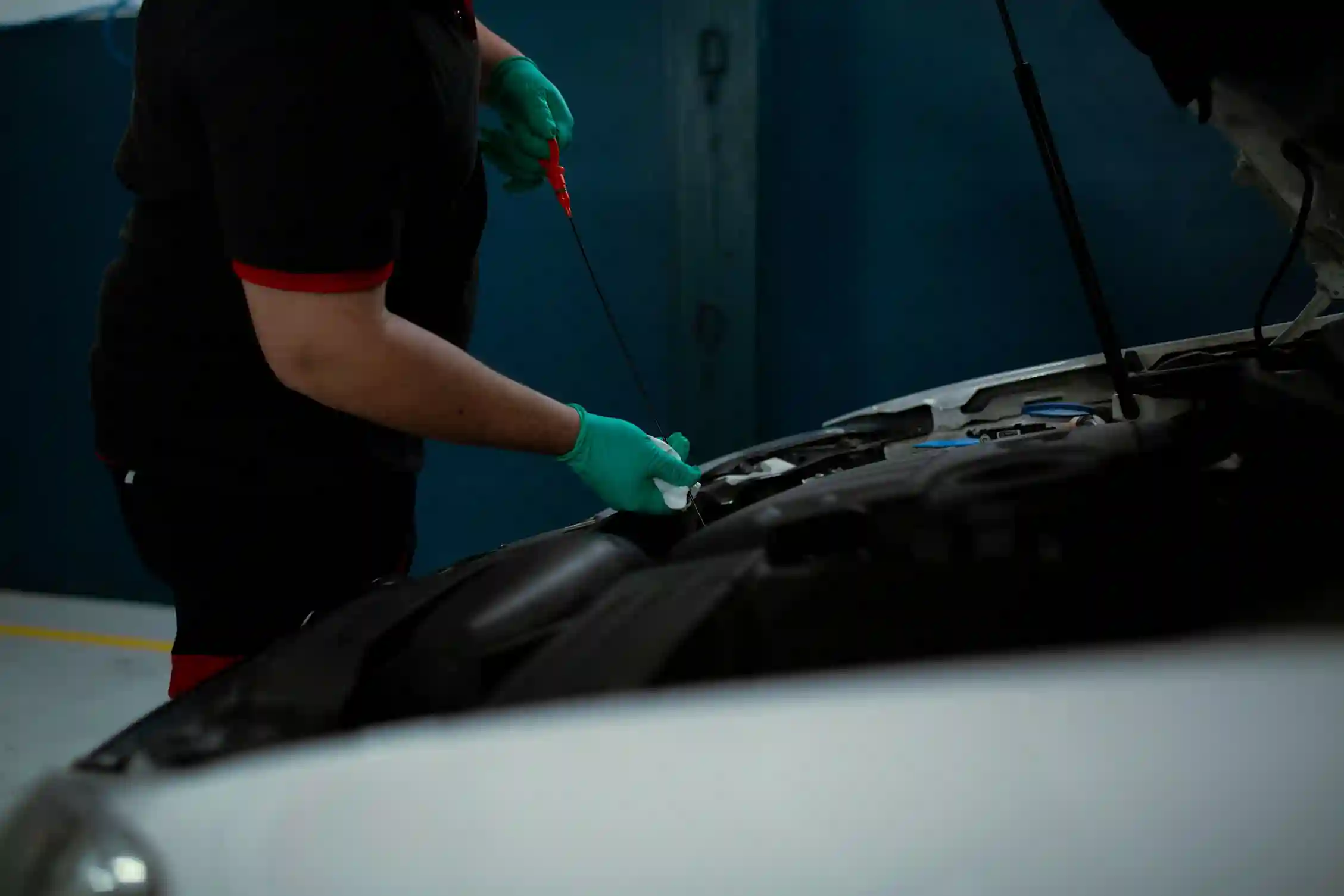 Mechanic pouring synthetic engine oil into a car
