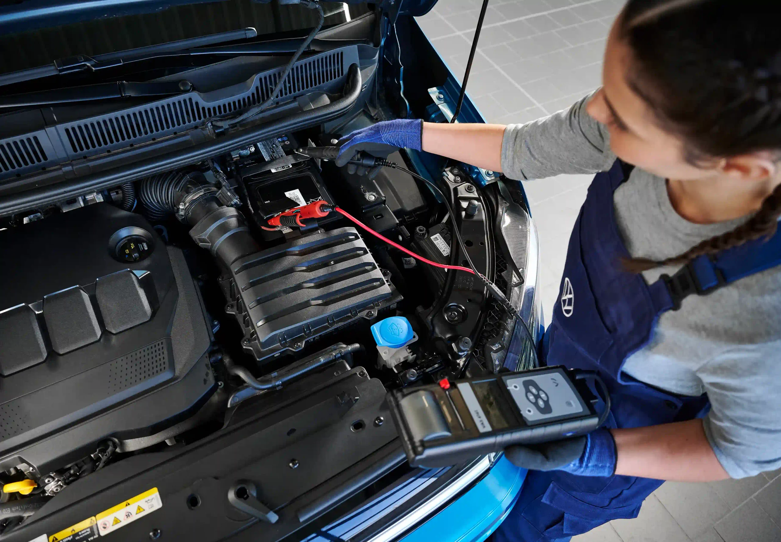 Technician checking Volkswagen car battery and electrical system